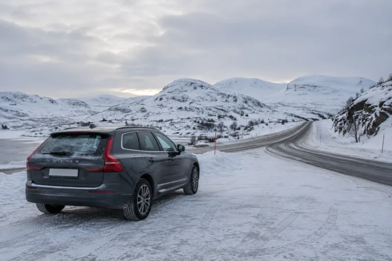 Bil på en brøytet venteplass ved en fjellvei om vinteren